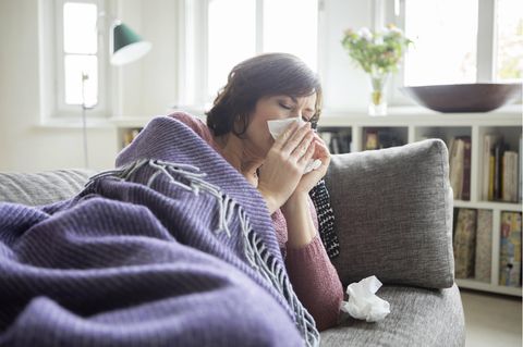 Krankmeldung benötigt: Eine kranke Frau auf dem Sofa