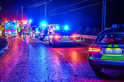 Polizeiautos und Krankenwagen stehen im Dunkeln auf der Landesstraße L564 bei Karlsruhe
