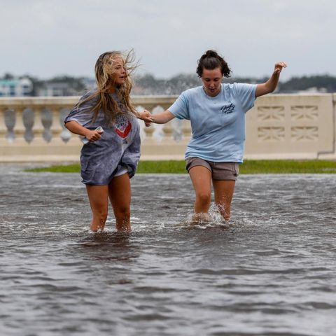 Zwei junge Frauen waten in Florida durch das von Hurrikan Helene verursachte Hochwasser