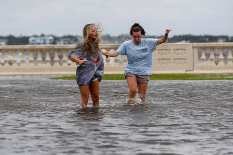 Zwei junge Frauen waten in Florida durch das von Hurrikan Helene verursachte Hochwasser