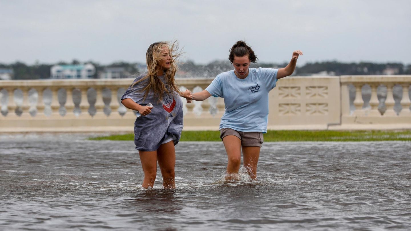 Zwei junge Frauen waten in Florida durch das von Hurrikan Helene verursachte Hochwasser