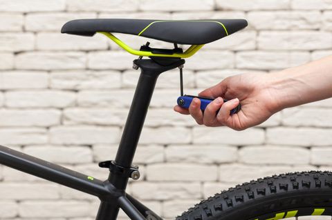 Fahrrad Multitool: Biker schraubt mit Inbus am Sattel