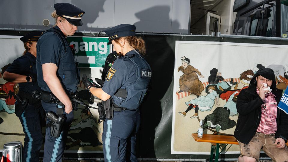 Polizeikontrolle auf dem Oktoberfest ein betrunkener Teilnehmer sitzt in Lederhose auf einer Bank