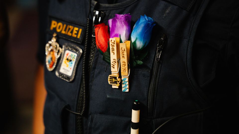Nahaufnahme einer Sicherheitsfeste eines Polizisten mit künstlichen Blumen am Revers