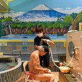 Ein Mann wird im Badehaus gewaschen