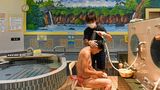 Ein Mann wird im Badehaus gewaschen