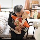 Alte Frau umarmt einen puppenähnlichen Roboter