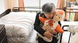 Alte Frau umarmt einen puppenähnlichen Roboter