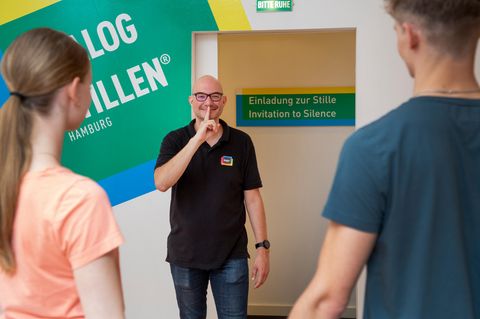 Der Gehörlose Tobias hält den Zeigefinder vor seine Lippen