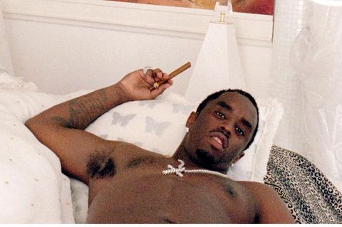 P. Diddy in einem Bett mit Zigarre in der Hand und Gemälde über dem Bett