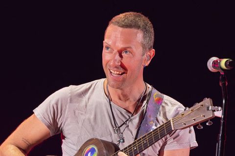 Coldplay-Frontmann Chris Martin spielt Gitarre auf der Bühne