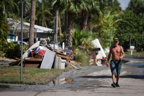 Ein Mann geht an einer Straße in Clearwater Beach in Florida entlang. Die Trümmer, die Hurrikan Helene hinterlassen hat, sind zusammengetragen und stehen zum Abtransport bereit. Das ganze Ausmaß des Monstersturms ist noch nicht bekannt. Bislang wurden 130 Tote gemeldet, doch Hunderte Menschen werden weiterhin vermisst