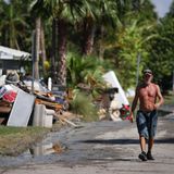 Ein Mann geht an einer Straße in Clearwater Beach in Florida entlang. Die Trümmer, die Hurrikan Helene hinterlassen hat, sind zusammengetragen und stehen zum Abtransport bereit. Das ganze Ausmaß des Monstersturms ist noch nicht bekannt. Bislang wurden 130 Tote gemeldet, doch Hunderte Menschen werden weiterhin vermisst