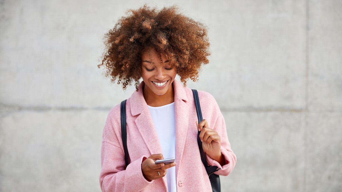 Unlimited-Tarif: Lächelnde Frau mit Handy in der Hand.