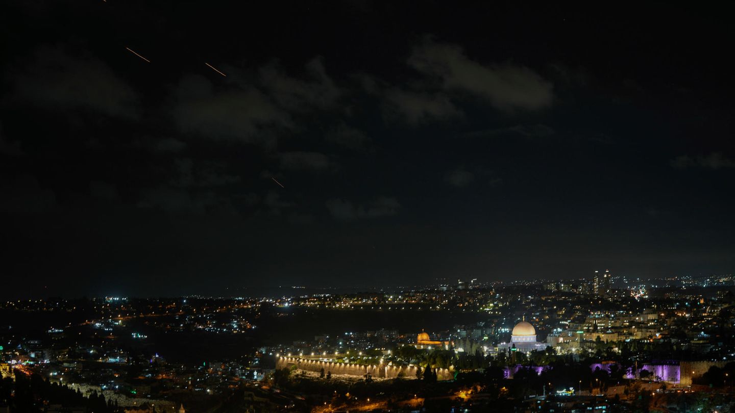 Geschosse fliegen über Jerusalem, während eine Sirene vor ankommenden Raketen aus dem Iran warnt