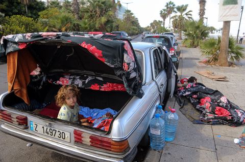 Ein verschlafener Junge sitzt im Kofferraum eines Autos im Libanon