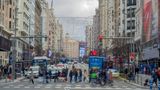 Fußgänger überqueren eine lebhafte Strasse in Madrid