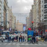 Fußgänger überqueren eine lebhafte Strasse in Madrid