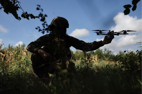 Ein russischer Soldat hält eine Drohne in der Hand