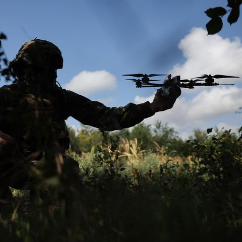 Ein russischer Soldat hält eine Drohne in der Hand