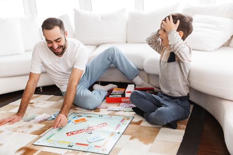 Familie: Vater und Sohn spielen Monopoly