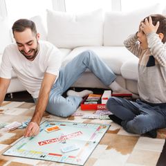 Familie: Vater und Sohn spielen Monopoly