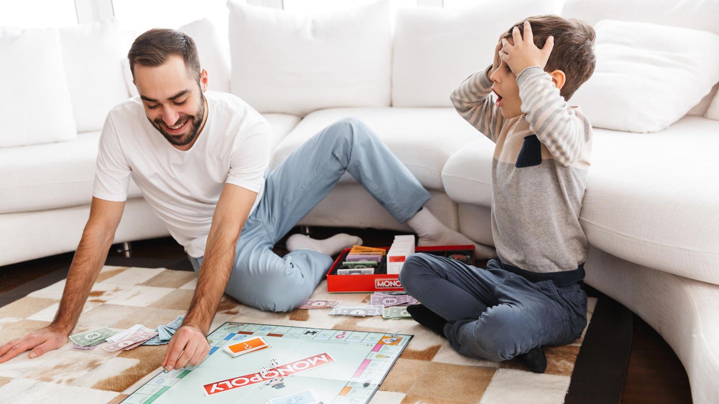 Familie: Vater und Sohn spielen Monopoly