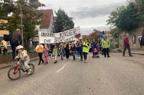 Eltern und Kinder auf einer Demonstrations mit Plakakten gegen hohe Kita-Gebühren