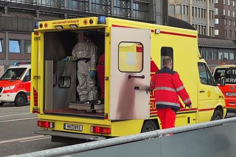 Marburg-Virus: Eine Einsatzkraft in Schutzkleidung steht in einem Rettungswagen der Feuerwehr vor dem Hauptbahnhof Hamburg