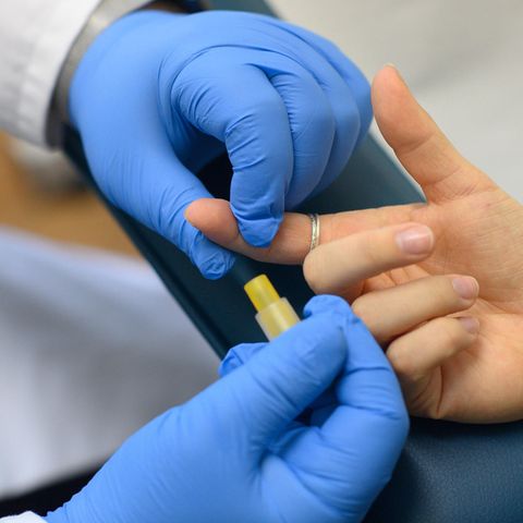 Ein Arzt nimmt einer Patientin Blut ab für einen HIV-Test