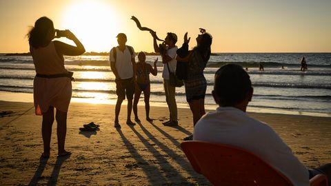 EIn Mann am Strand von Tel Aviv, Israel, bläst in ein Widderhorn