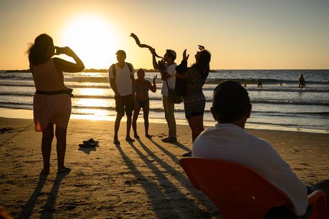 EIn Mann am Strand von Tel Aviv, Israel, bläst in ein Widderhorn