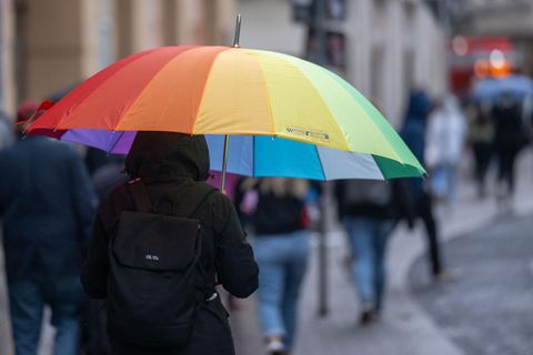 Eine Fußgängerin schützt sich in der Altstadt mit einem Schirm vor dem Wetter
