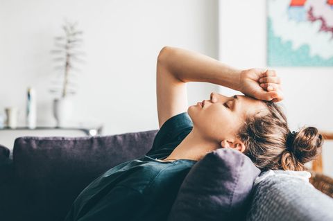 Beziehung: Eine verzweifelte Frau liegt auf einem Sofa
