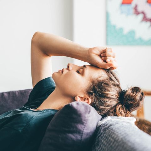 Beziehung: Eine verzweifelte Frau liegt auf einem Sofa