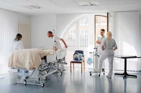 Pflege: Übungsraum der Rehaklinik mit drei Azubis und einem Ausbilder