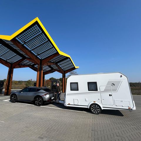 Wohnwagen mit E-Auto an Ladestation