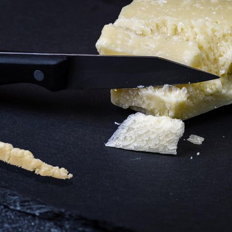 Ein Parmesankäse Block mit einer Line Parmesan auf einem Schieferbrett