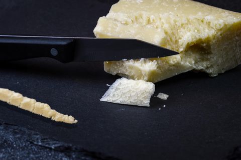 Ein Parmesankäse Block mit einer Line Parmesan auf einem Schieferbrett
