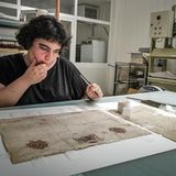 Restauratorin Milena Mammoliti untersucht die Pergamentseite eines alten Buches