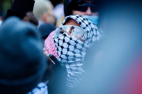 Eine Demonstrantin marschiert mit Schutzbrille durch Kreuzberg in Berlin