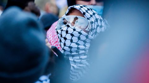 Eine Demonstrantin marschiert mit Schutzbrille durch Kreuzberg in Berlin