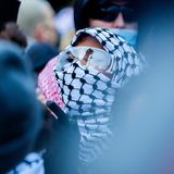 Eine Demonstrantin marschiert mit Schutzbrille durch Kreuzberg in Berlin