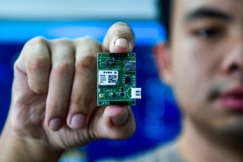 Ein Student zeigt einen Positionierungschip im staatlichen chinesischen Schlüssellabor für öffentliche Big Data