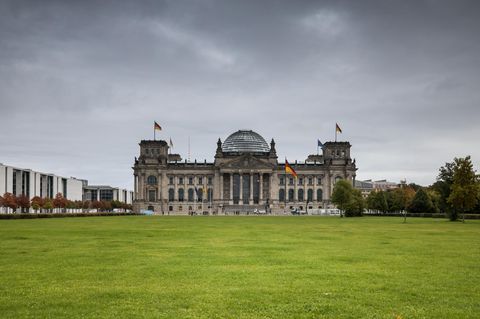 Ein Blick von weit weg auf den Bundestag mit dunklen Wolken im Hintergrund