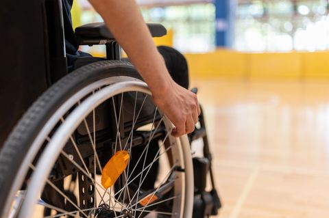 Rollstuhlfahrende Person in Sporthalle