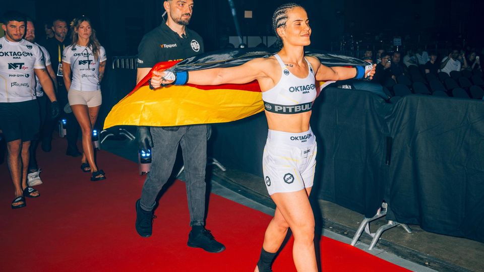 Kämpferin Haifa Reso, Bantam-gewicht (bis 61,2 Kilo), läuft mit Flagge in die Arena ein MMA