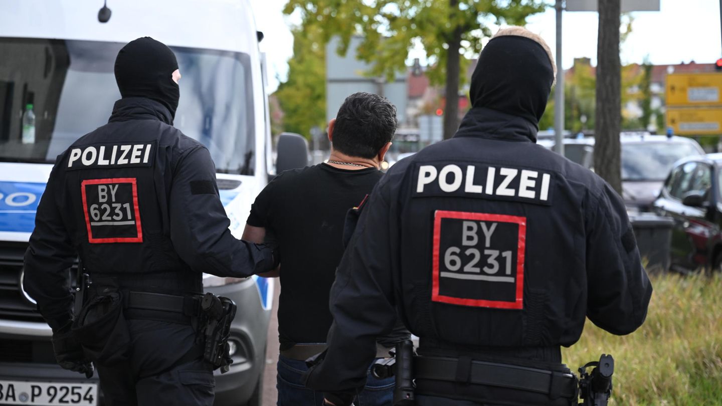 Razzia in mehreren Bundesländern: Polizisten führen ein Mitglied einer georgischen Hehlerbande ab