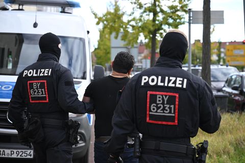Razzia in mehreren Bundesländern: Polizisten führen ein Mitglied einer georgischen Hehlerbande ab