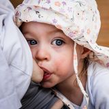 Nahaufnahme von einem Kind, das gerade von der Mutter gestillt wird